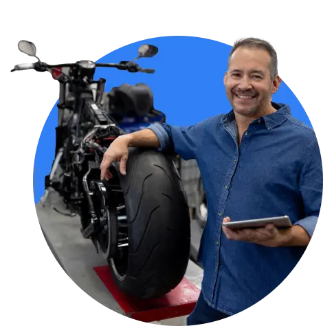 Mechanic with a tablet standing beside a motorbike