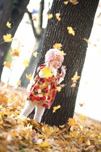 child-playing-with-autumn-leaves